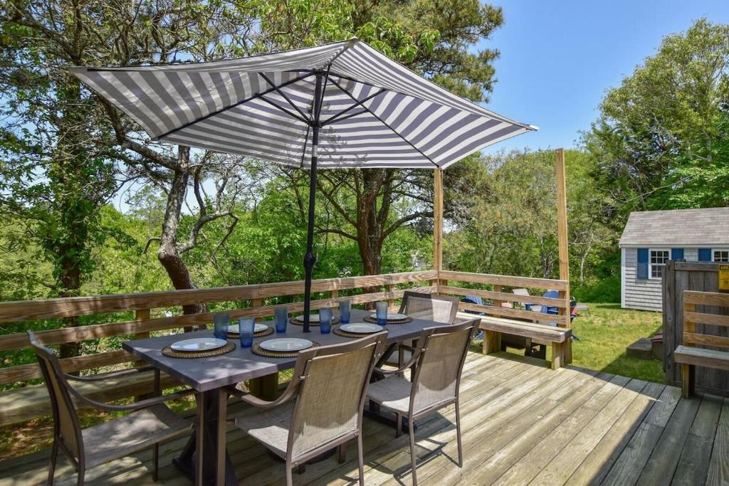 una mesa de patio con una sombrilla en la terraza en Beautiful Home Close to Ponds and Beach, en Brewster