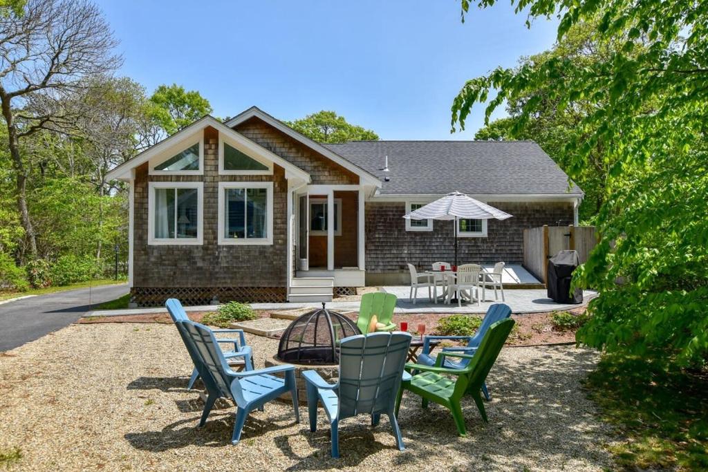 a house with chairs and a table in front of it at Spacious Home by Beach Dog Welcome in Brewster
