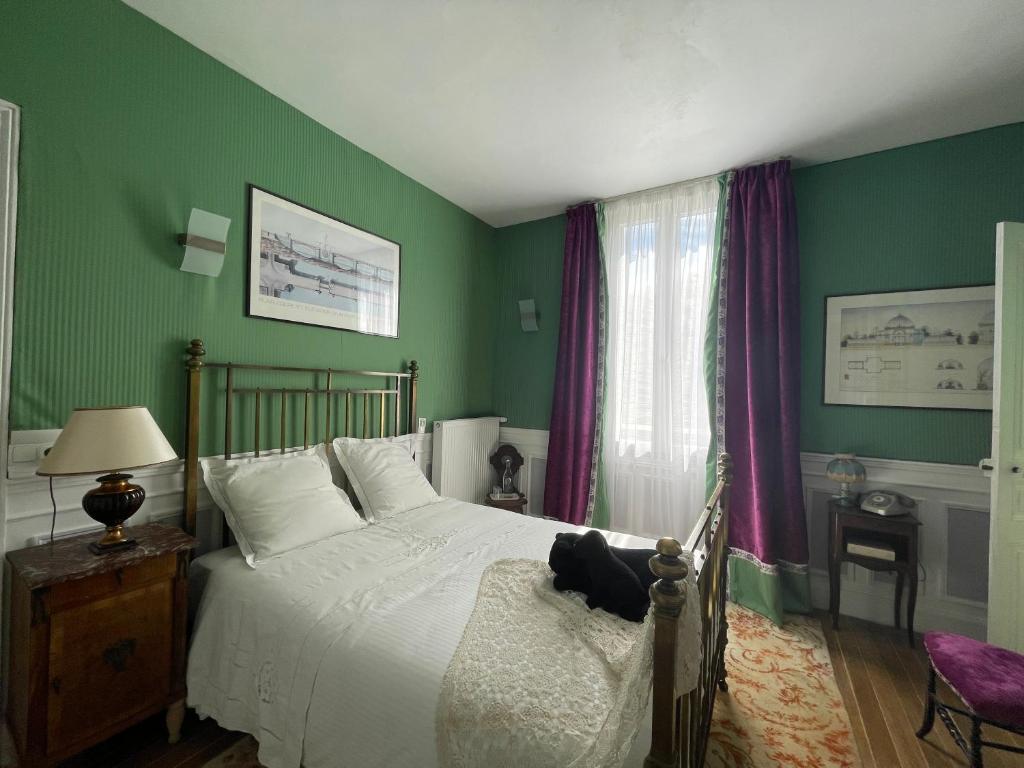 a green bedroom with a bed and a window at La Bonne Maison 3 in Troyes