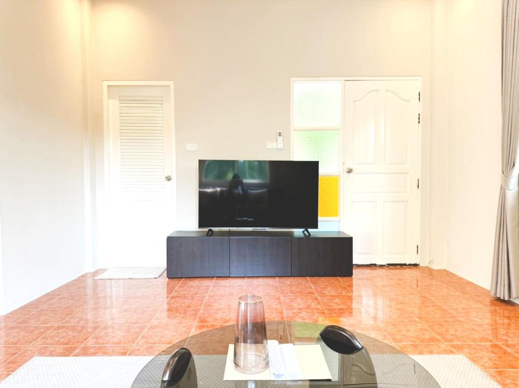 a living room with a flat screen tv on a table at Prime Hill Kathu Phuket E1 in Phuket Town