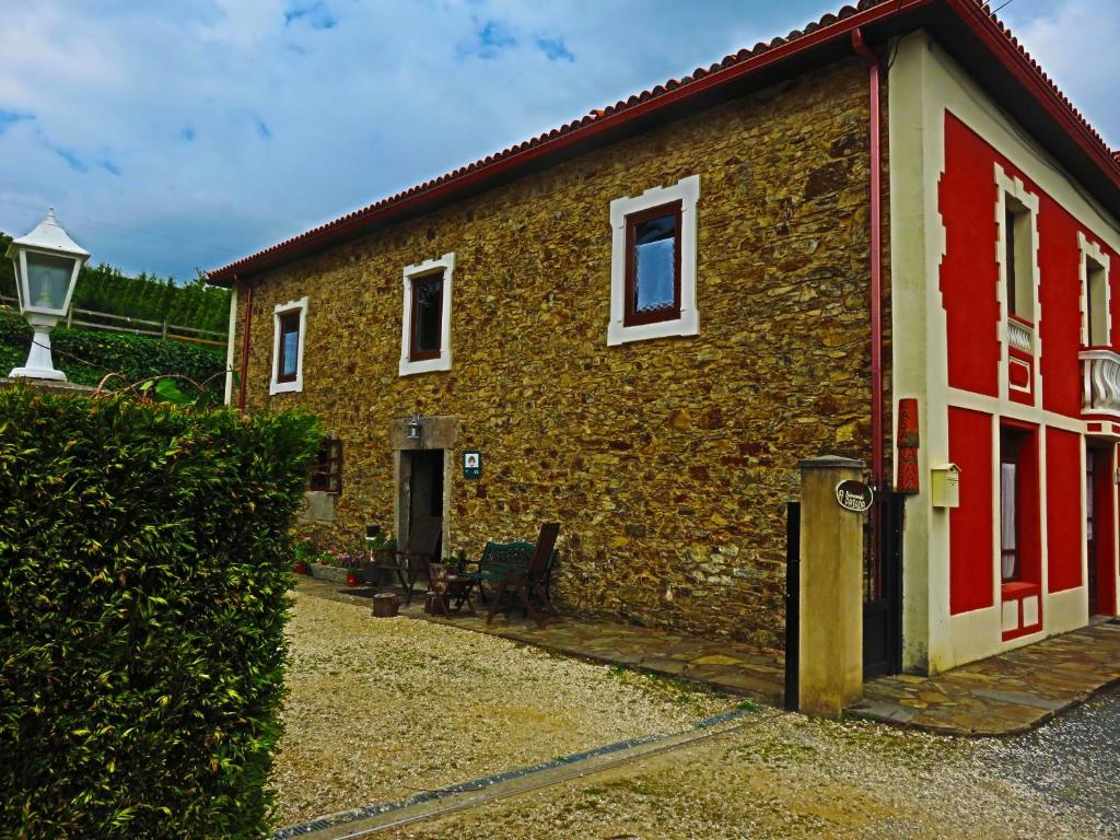 un edificio de ladrillo con una puerta roja y blanca en Casa Rural A Pasada en Cedeira