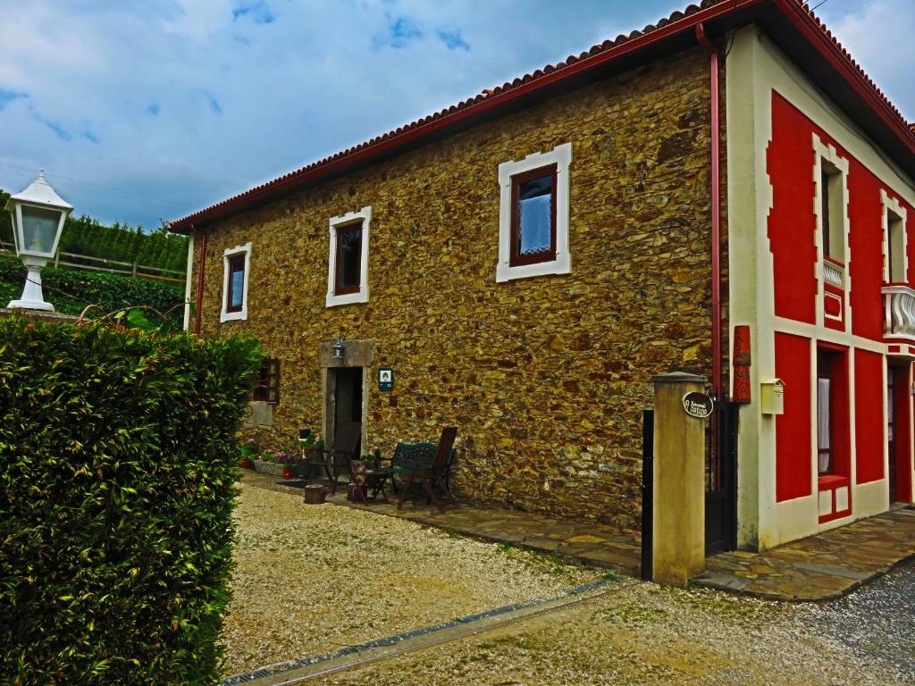 un edificio de ladrillo con una puerta roja y blanca en Casa Rural A Pasada, en Cedeira