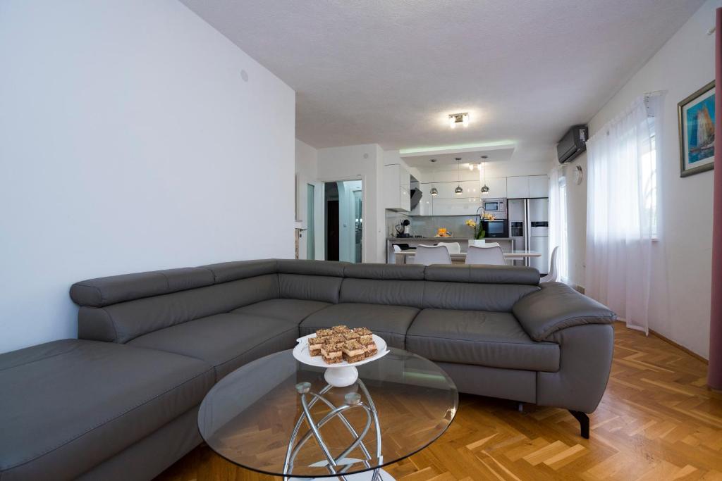 a living room with a couch and a glass table at M&M Pelivan apartment in Kaštela