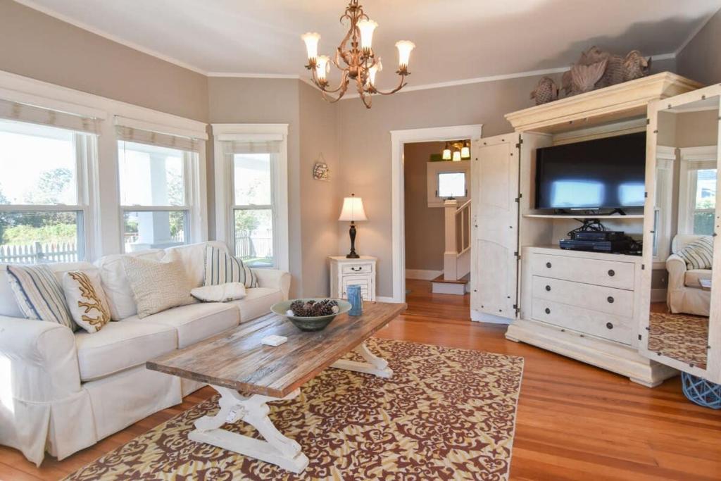 a living room with a white couch and a table at Walk to Beach at Historic Sears Kit Home in Dennis
