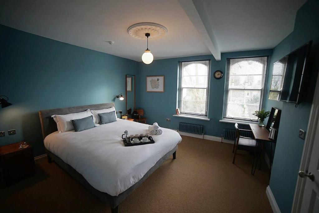 a bedroom with a large bed with blue walls at The Alma Taverns Boutique Suites - Room 1 - Hopewell in Bristol