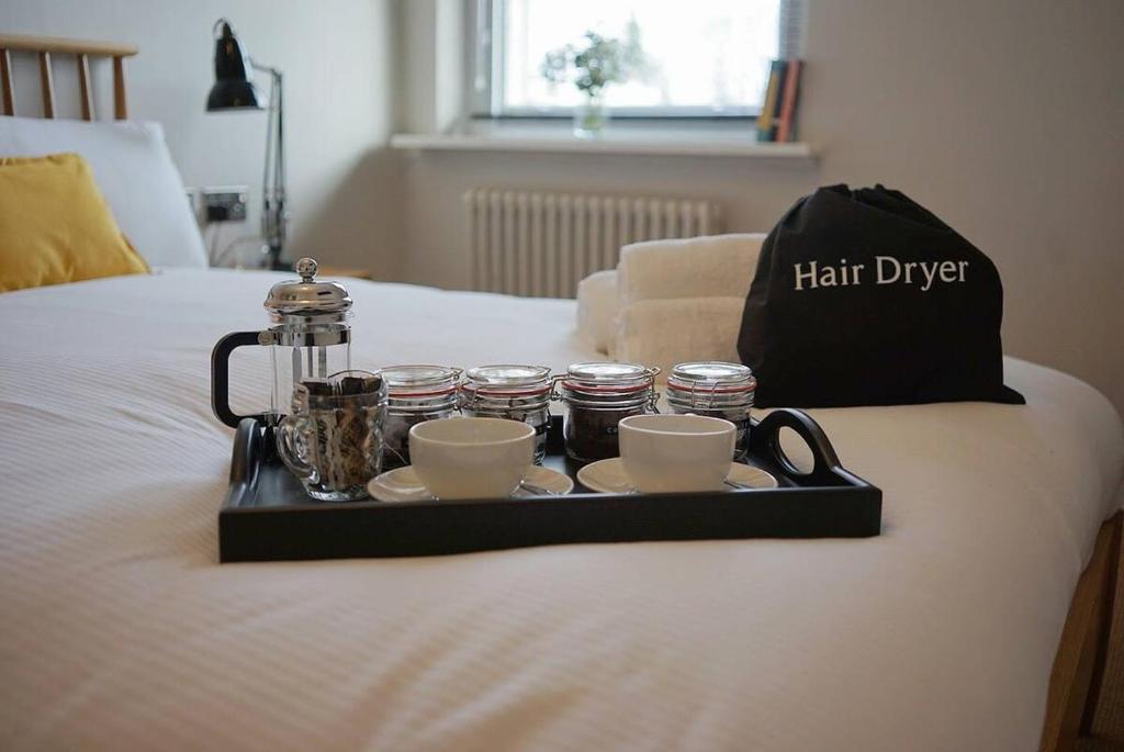 un vassoio con tazze e tazzine da caffè su un letto di The Alma Taverns Boutique Suites - Room 3 - Hopewell a Bristol