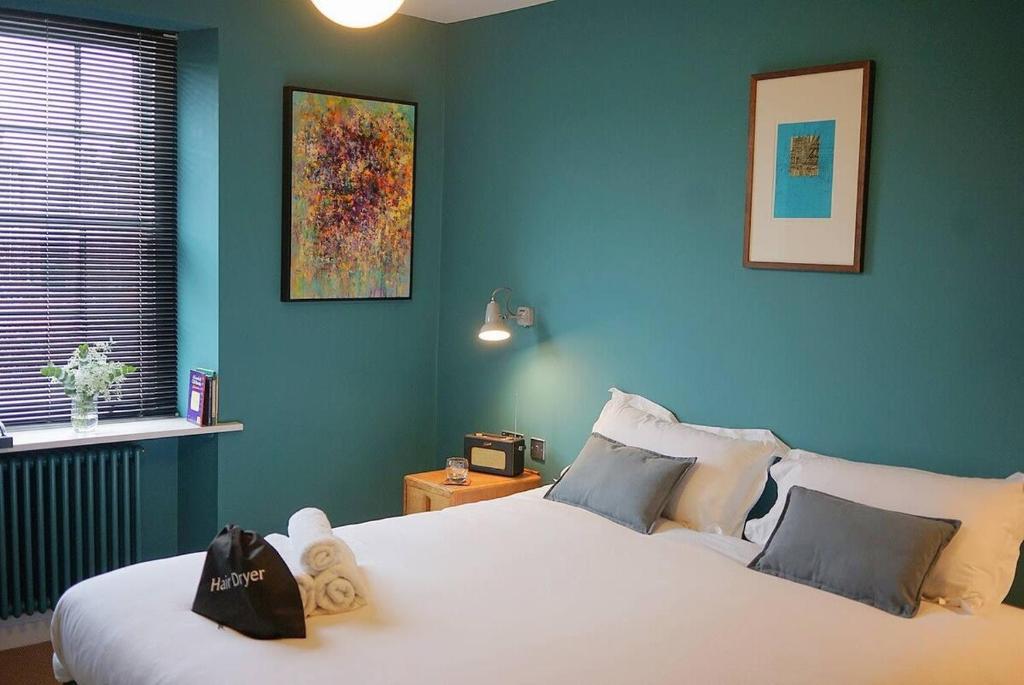 a bedroom with a large white bed with blue walls at The Alma Taverns Boutique Suites - Room 5 - Hopewell in Bristol