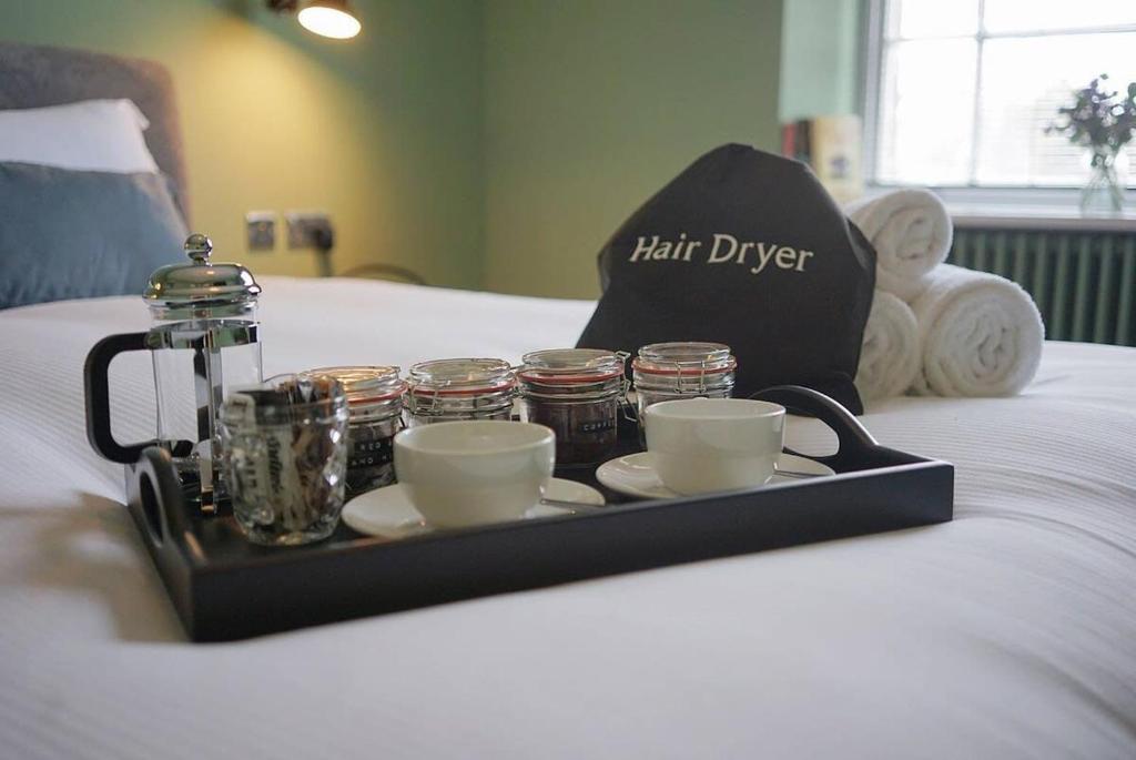 a tray with cups and tea cups on a bed at The Alma Taverns Boutique Suites - Room 4 - Hopewell in Bristol