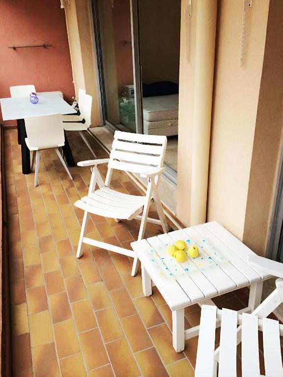 a porch with two chairs and a table and a table and chairs at Monaco Studio "907" in Monte Carlo