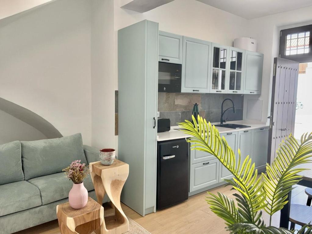 een woonkamer met een bank en een keuken bij El rincón de Regina in Córdoba