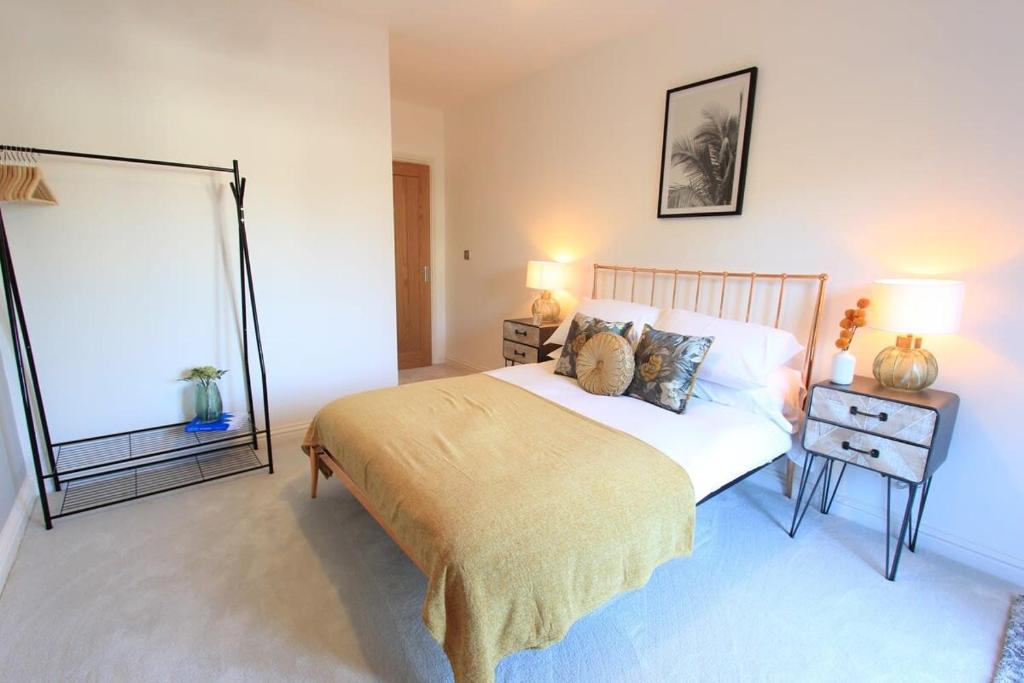 a bedroom with a bed and a table with two lamps at Cabot Mews Apartment 6 in Bristol