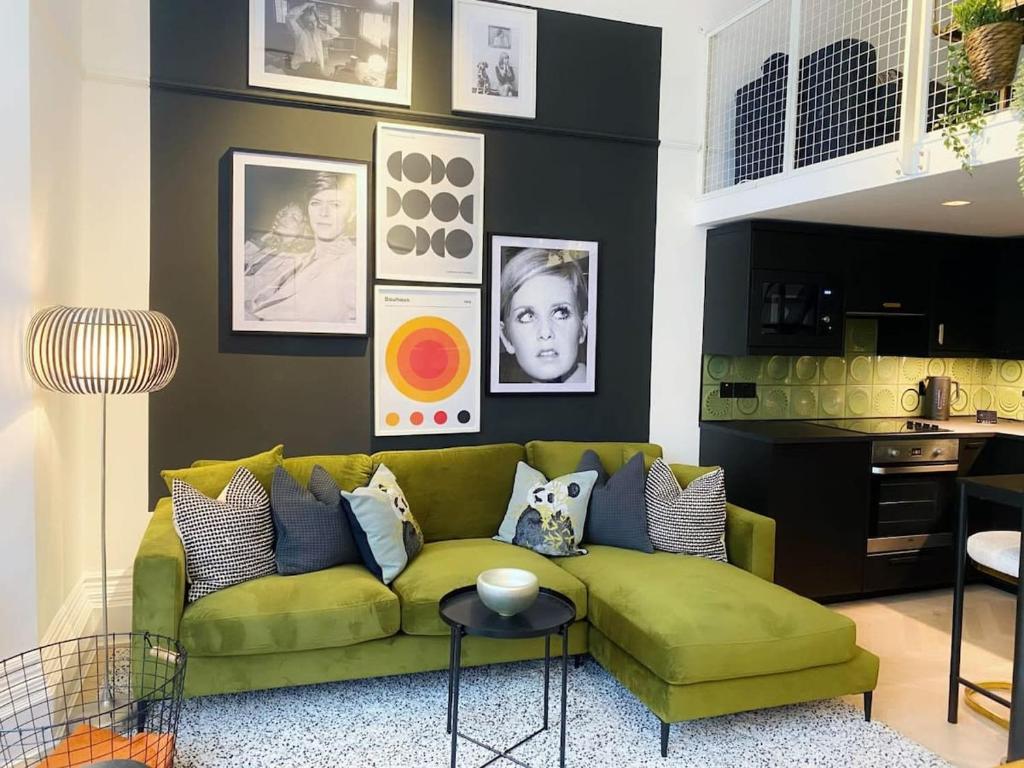 ein Wohnzimmer mit einem grünen Sofa und einer Küche in der Unterkunft Modern and Bright Three Bed Apartment in Bristol
