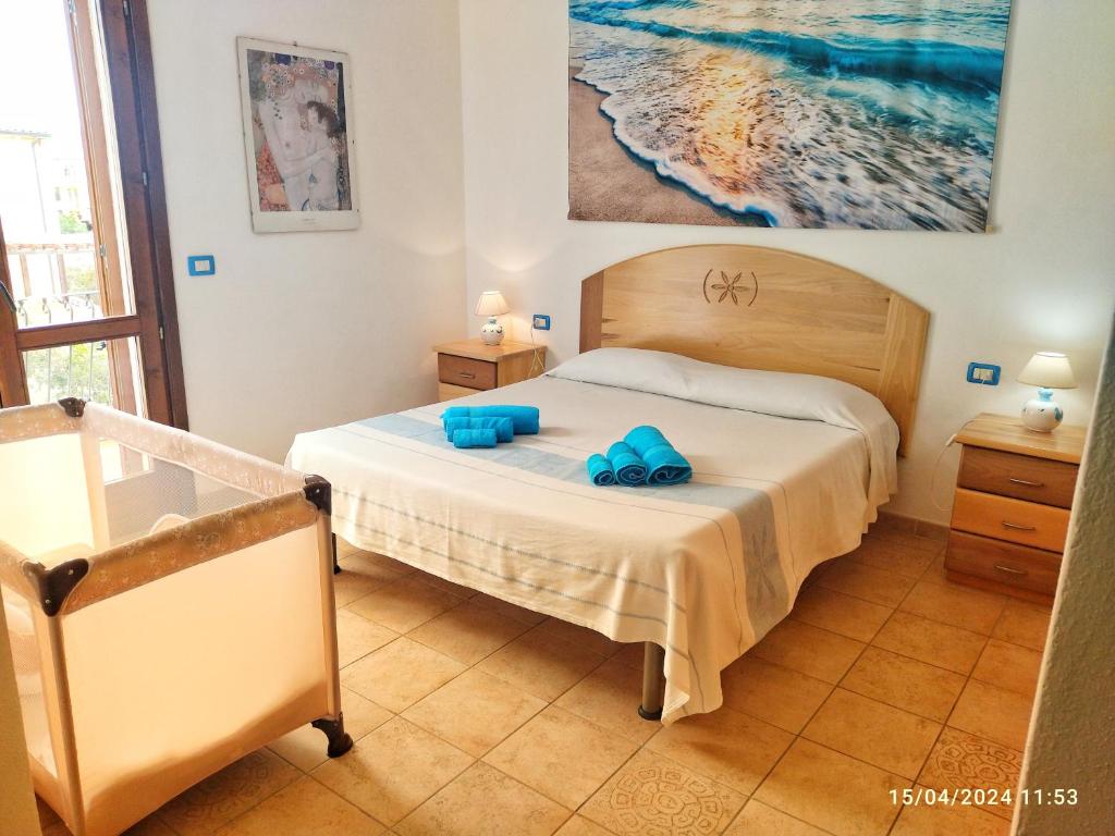 - une chambre avec un lit et des serviettes bleues dans l'établissement Incantevole Casa Vacanze MIMOSA La Maddalena, à La Maddalena