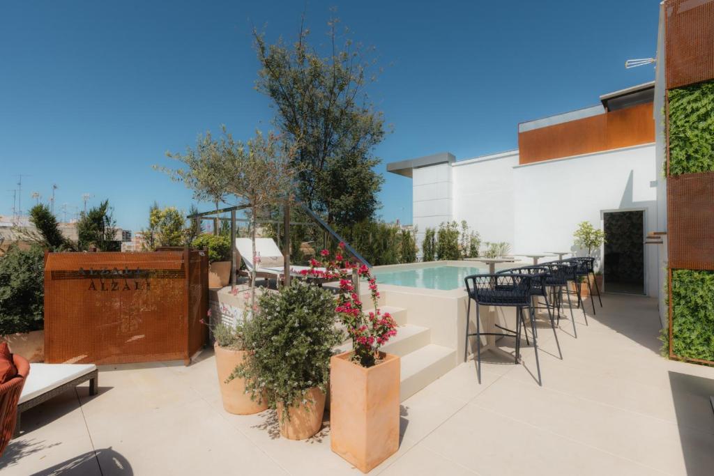 a patio with tables and chairs and a pool at Cavalta Boutique Hotel GL in Seville