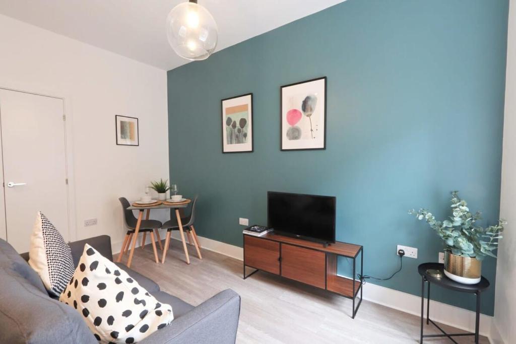 a living room with a couch and a flat screen tv at Alliance House - Hopewell in Bristol