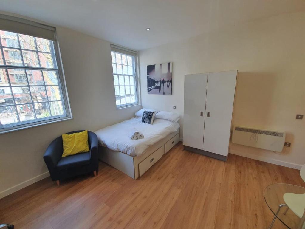 a bedroom with a bed and a cabinet and a chair at Harford House Studios - Hopewell in Bristol