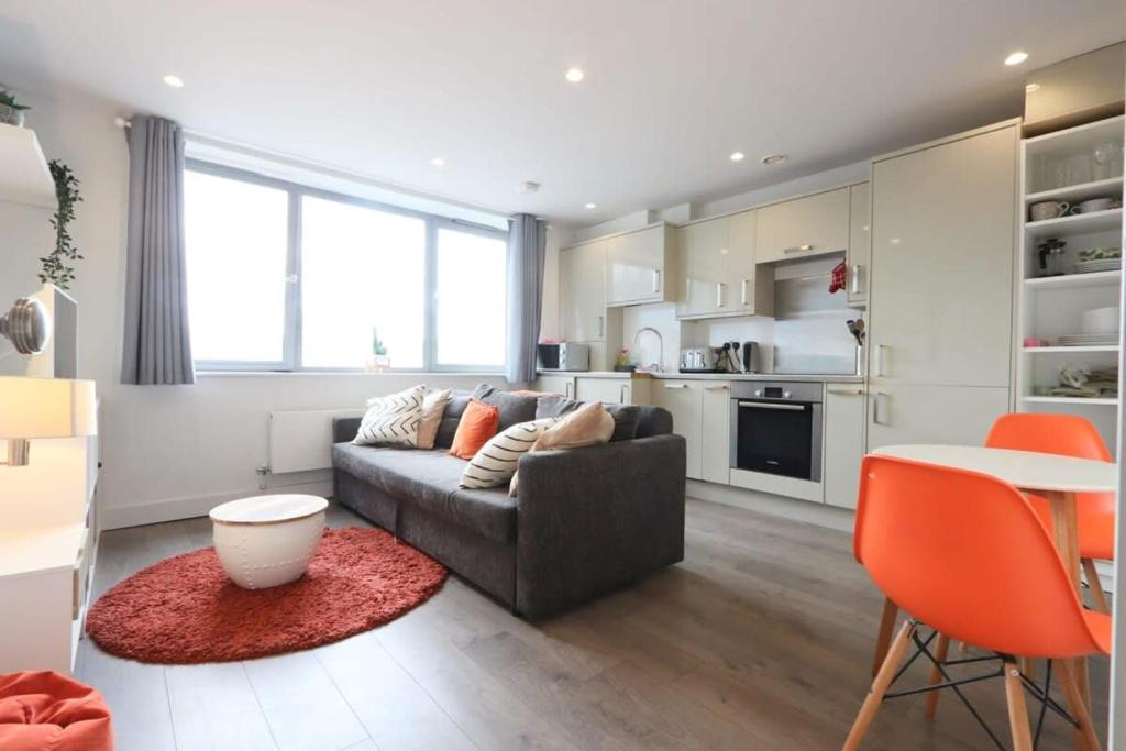 a living room with a couch and a table and a kitchen at Flat 14 Southey House in Bristol