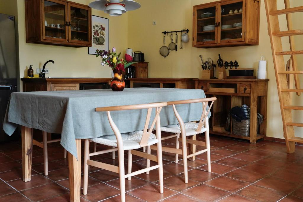 a kitchen table with two chairs and a vase of flowers at Apfelhof Biesenbrow in Biesenbrow