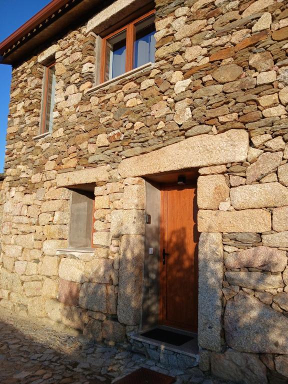 un edificio de piedra con una puerta de madera. en Casa da Eira - Murça, en Murça