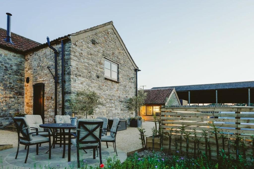 a patio with chairs and a table in front of a building at The Cottage- Hopewell in Bristol