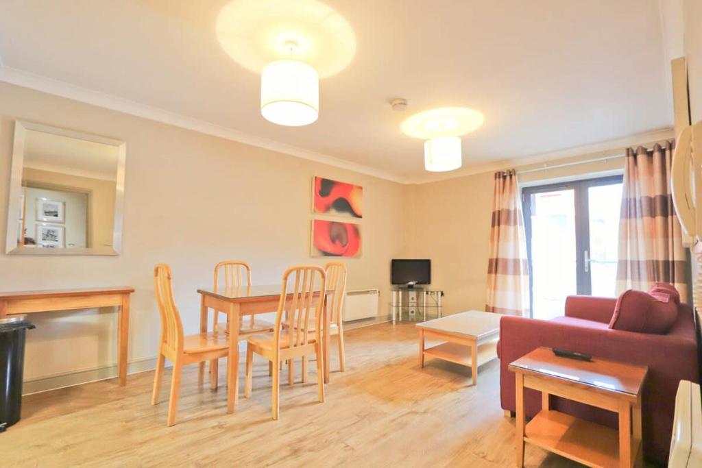 uma sala de estar com um sofá, uma mesa e cadeiras em City Centre 1 Bed Apartment em Bristol