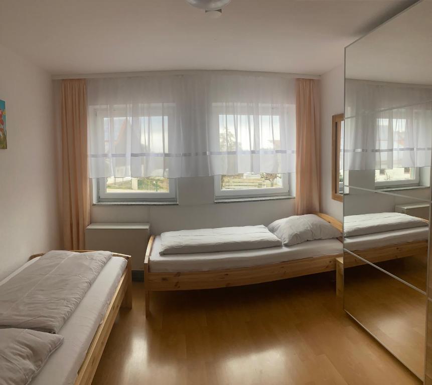 two beds in a room with two windows at Ferienwohnung "Zwei Birken" in Ellwangen