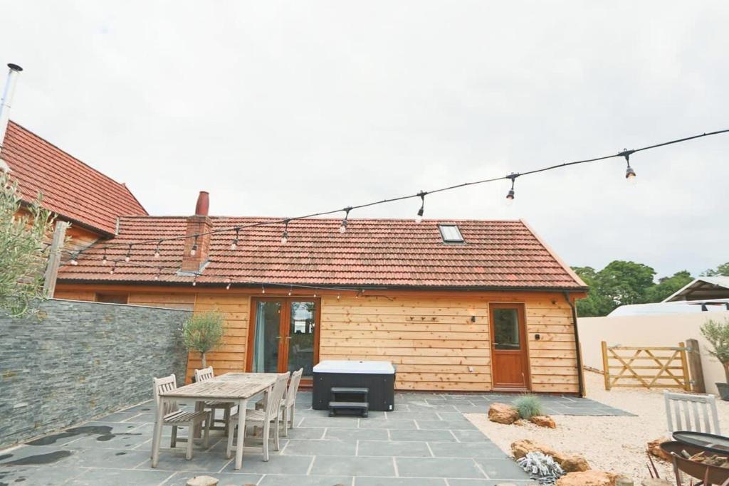 a patio with a table and chairs and a house at Cedar lodge - Hopewell in Bristol