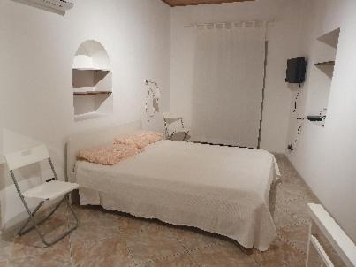 - une chambre blanche avec un lit et une chaise dans l'établissement Peri Peri Holiday Home Catania, à Catane