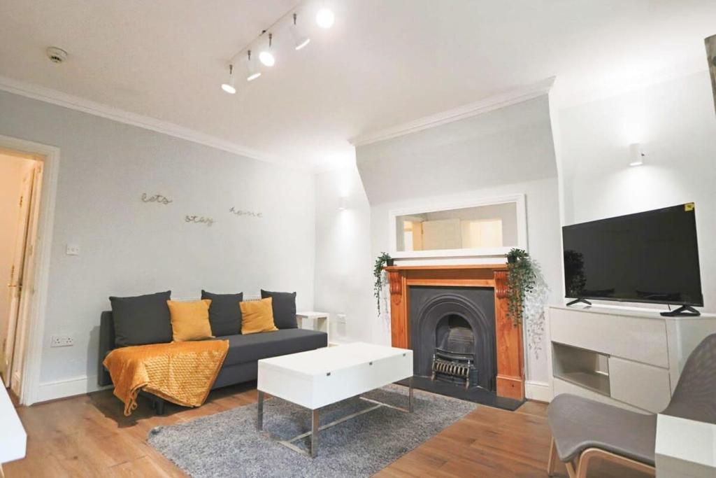 uma sala de estar com um sofá e uma lareira em Kingsdown Apartment - basement with Parking em Bristol