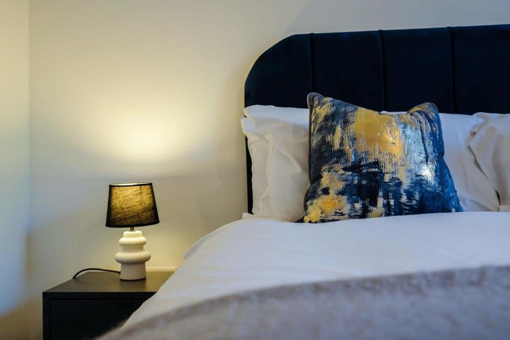 uma cama com uma almofada azul e amarela e um candeeiro em Hotwells apartments flat 2 - Hopewell em Bristol