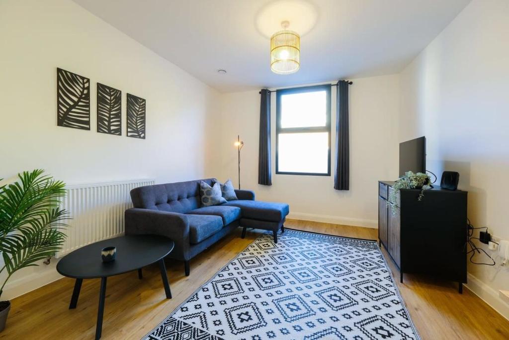 a living room with a blue couch and a table at Hotwells apartments flat 5 - Hopewell in Bristol