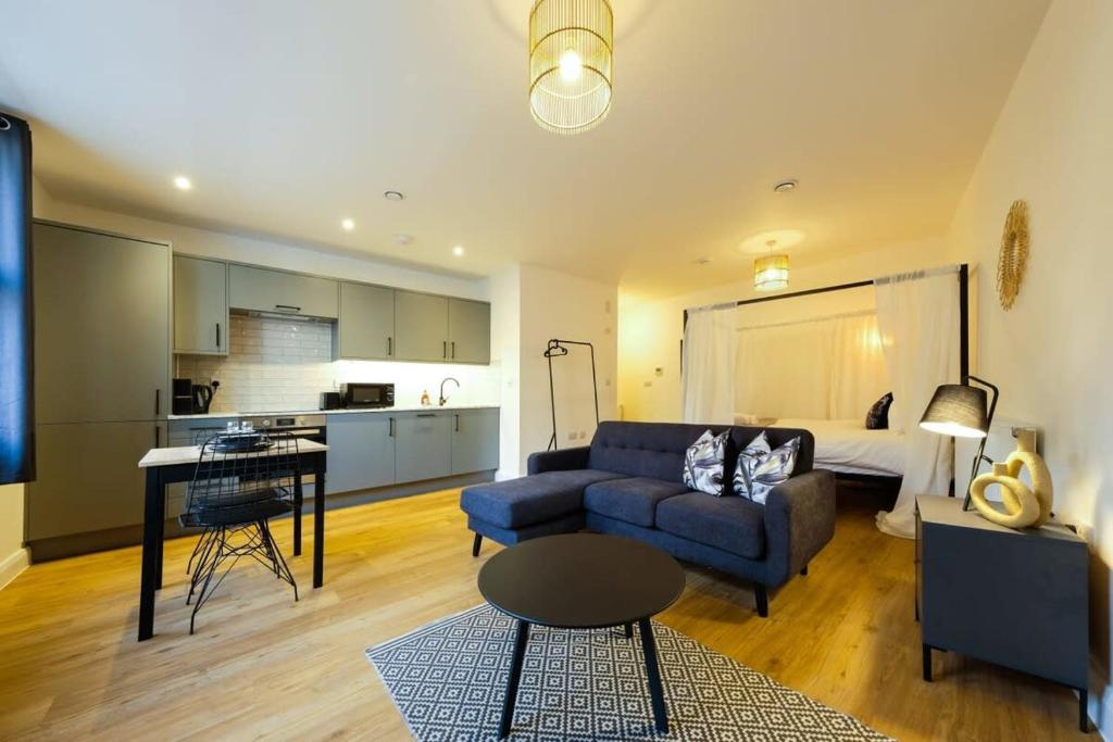 a living room with a blue couch and a kitchen at Hotwells apartments flat 1 - Hopewell in Bristol