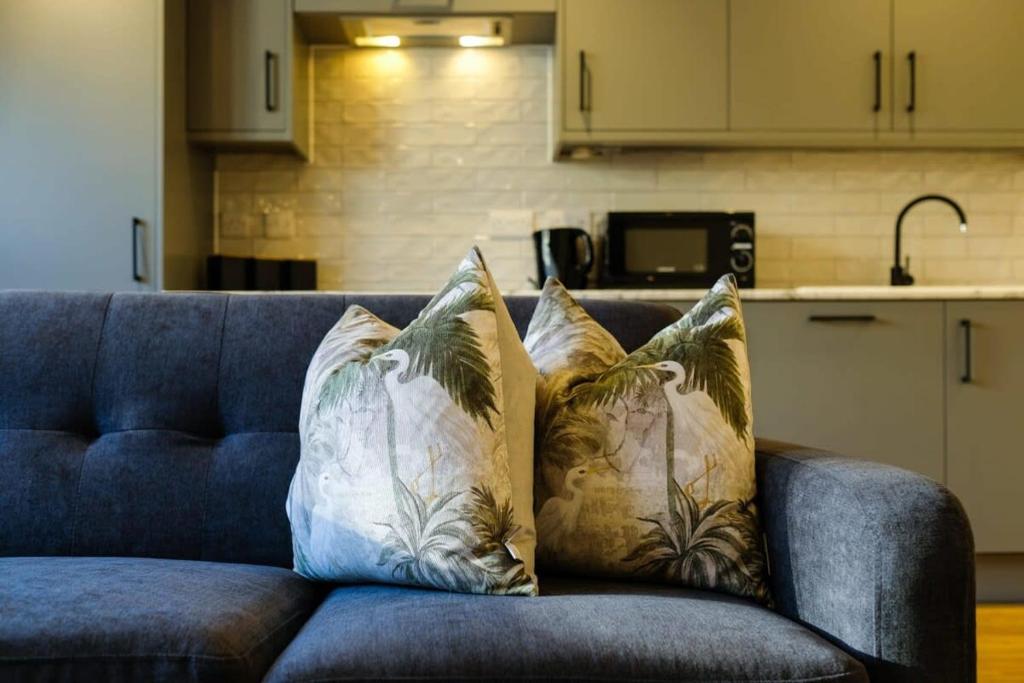um sofá azul com almofadas na cozinha em Hotwells apartments flat 7- Hopewell em Bristol