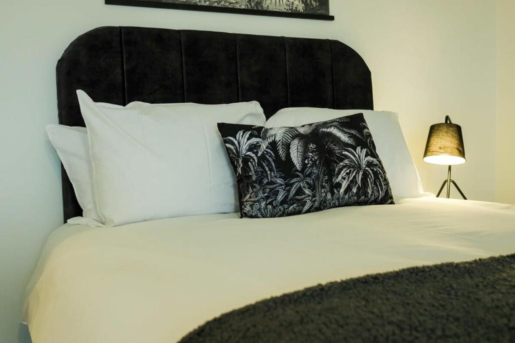 a bedroom with a white bed with a black headboard and pillows at Hotwells apartments flat 8- Hopewell in Bristol