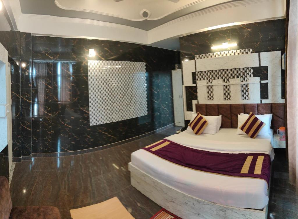 een hotelkamer met een bed en een douche bij Hotel Sunshine in Katra