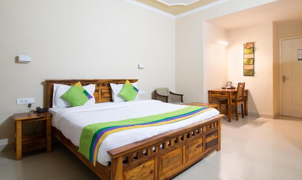 a bedroom with a large bed and a table at Treebo The Anchorage Malviya Nagar in Jaipur