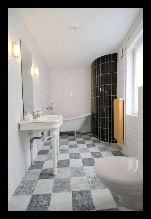 La salle de bains est pourvue d&#39;un lavabo, d&#39;une baignoire et de toilettes. dans l&#39;établissement Appartements Baron Bouvier, à Vesoul