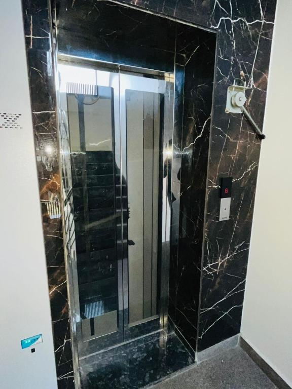 a bathroom with a glass shower with a mirror at Hotel in New Delhi