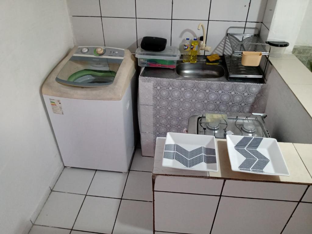 una pequeña cocina con lavadora y fregadero en Kitnet aconchegante en Olinda