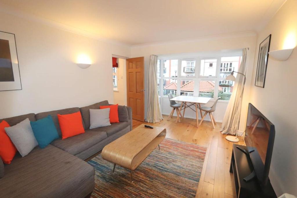 uma sala de estar com um sofá e uma mesa em Quiet riverside apartment with views and parking- em Bristol