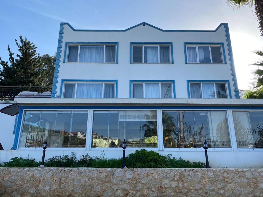 a blue house with large windows at Denge Pansiyon in Kaş