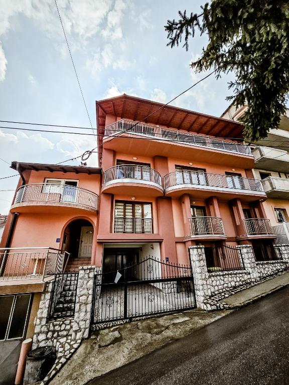 an orange building with balconies on a street at Lux Villa Emina in Tuzla