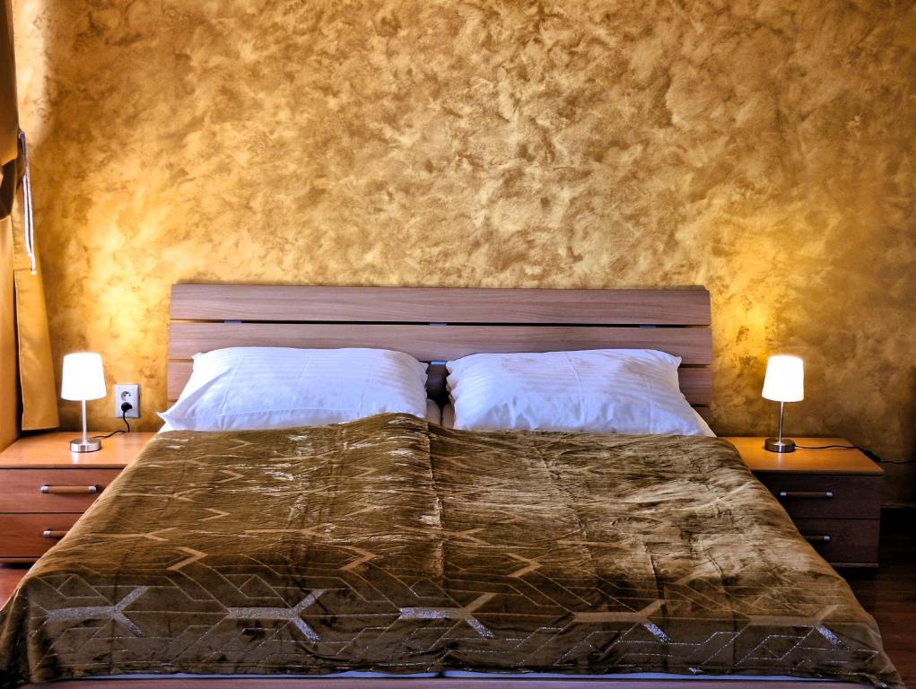 - une chambre avec un grand lit et 2 tables de chevet dans l'établissement Penzión Villa Agnes, à Smolenice