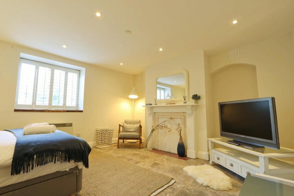 a bedroom with a bed and a tv and a fireplace at Spacious Boutique Apartment Clifton King Size Bed in Bristol