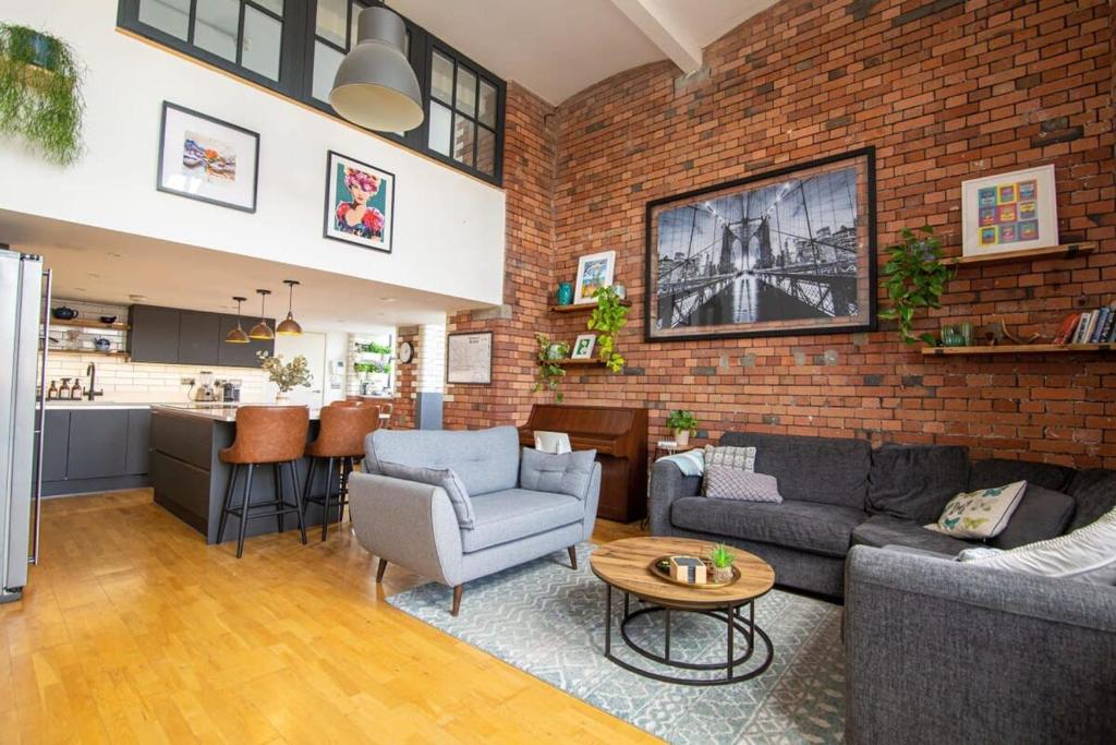 a living room with a couch and a brick wall at The Robinson Building in Bristol
