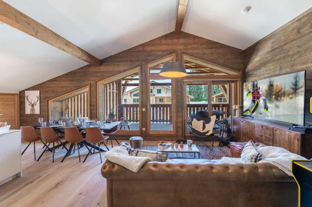 un salon avec un canapé et une table dans l'établissement 4 bedroom duplex with large balcony and parking, à Megève