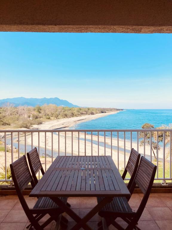 une table et des chaises sur un balcon avec la plage dans l'établissement Punta di Mare, à Linguizzetta
