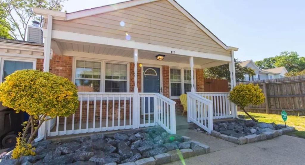 Casa pequeña con porche blanco y rocas en Cheerful 2 Bedroom Home near Virginia Wesleyan, en Virginia Beach