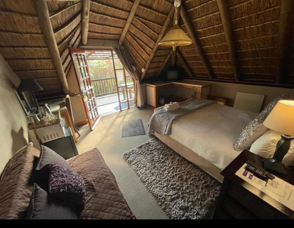 a bedroom with a large bed and a large window at Midrand Wild Goose Guest House Backup Power in Midrand