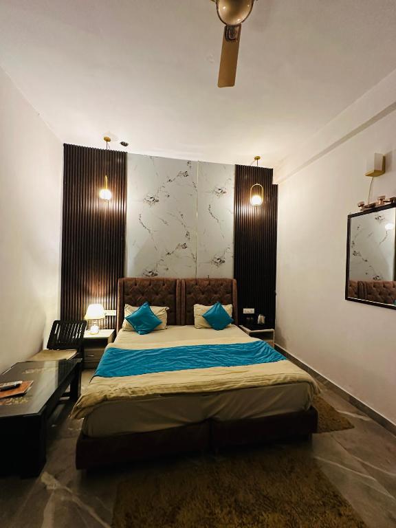 a bedroom with a large bed with blue pillows at Shivjot hotel in Kharar